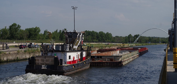 A tow boat pushing a barge on a river.
